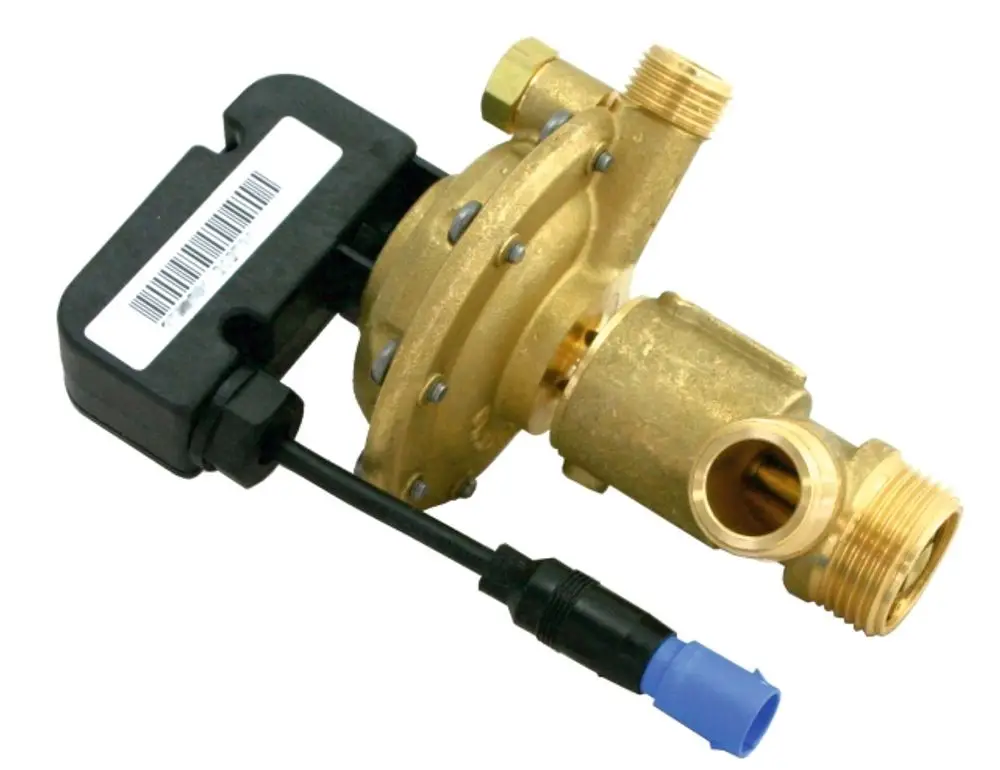 Dreiwegeumschaltventil in gelber Messingfarbe mit elektrischer Ansteuerung, produziert von Wolf. Verbindungsteile für eine hydraulische Installation sind sichtbar.